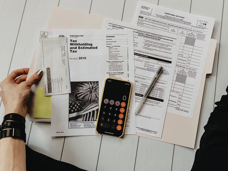 A person is holding a pen and calculator