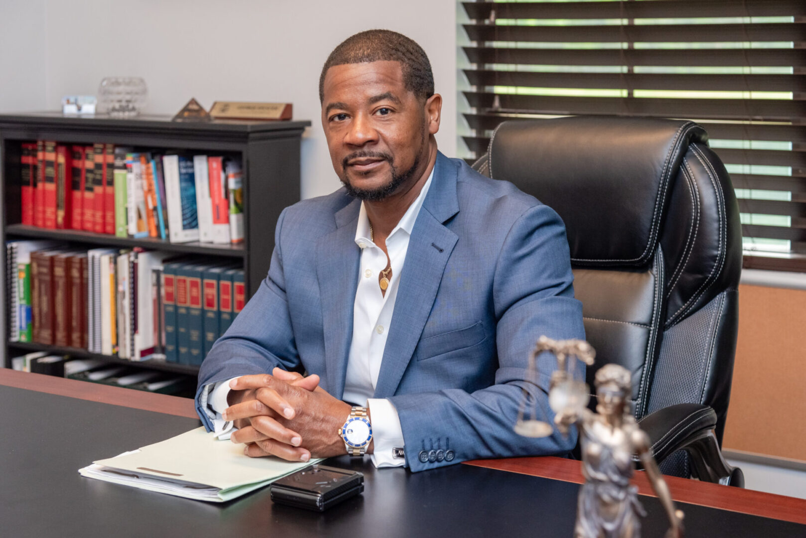 A man sitting at his desk in front of some books.