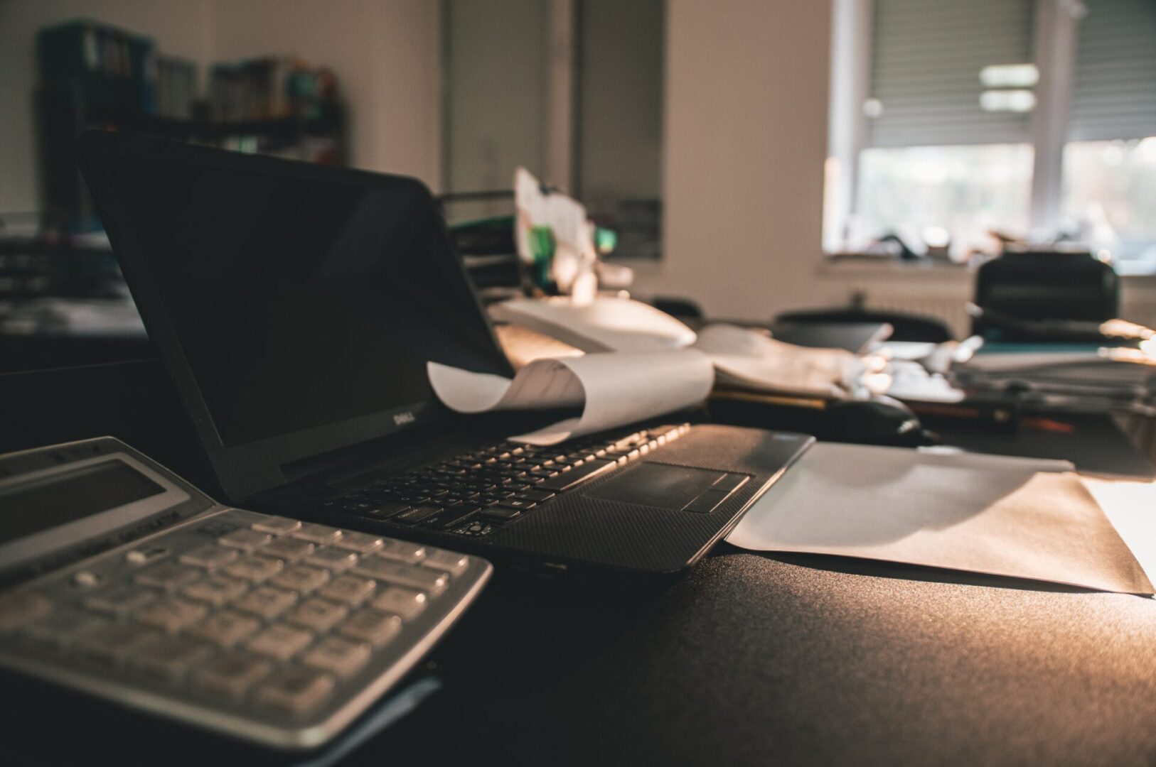 A laptop and keyboard on top of a desk.