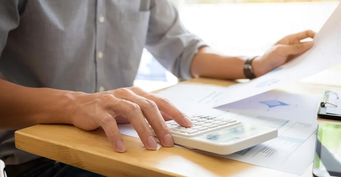 A person using a laptop on top of a table.